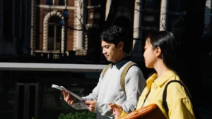 Due studenti universitari camminano nel campus parlando dei loro appunti