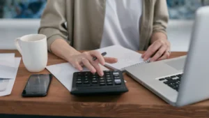 Lavoratore autonomo calcola i contributi con calcolatrice e laptop
