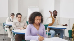 Studenti concentrati mentre svolgono una prova scritta in aula