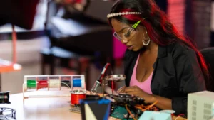Studentessa al lavoro su un progetto di elettronica con il saldatore