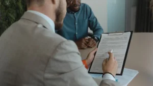 Un recruiter esamina i documenti di un candidato durante un colloquio di lavoro
