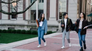 Gruppo di studenti universitari che camminano nel campus in una giornata di sole